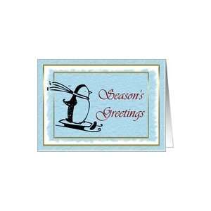 Seasons Greetings with skiing penguin on blue snow background Card