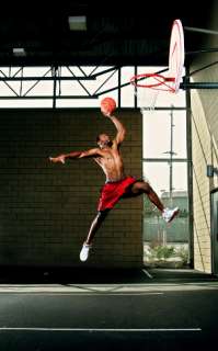 Man wearing basketball shoes, slam dunking a basketball